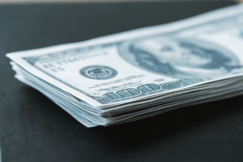 selective focus of stack with dollar banknotes on black