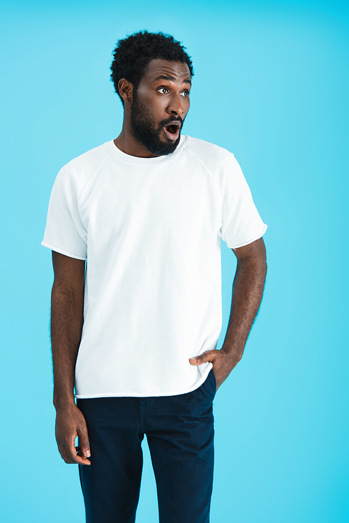 shocked african american man in white t-shirt, isolated on blue