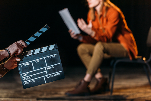 selective focus of actor with clapboard in front