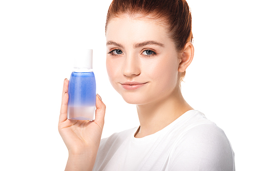 beautiful smiling teen girl with clean skin holding bottle with blue makeup remover, isolated on white