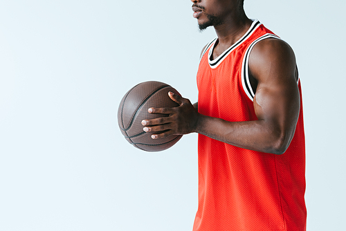 cropped view of african american sportsman holding basketball ball isolated on grey