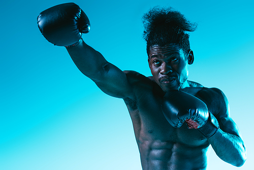 shirtless african american sportsman with muscular torso on blue background
