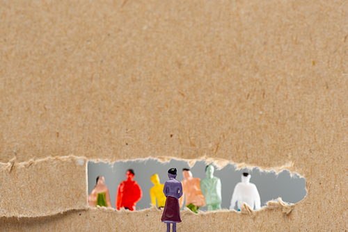 Concept of social rights with people figures near cardboard with hole isolated on grey, panoramic shot