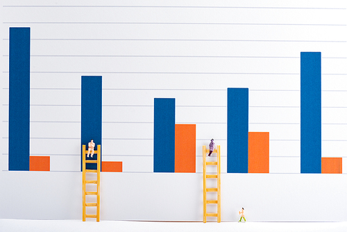 People figures with ladders on white surface with charts at background, equality concept