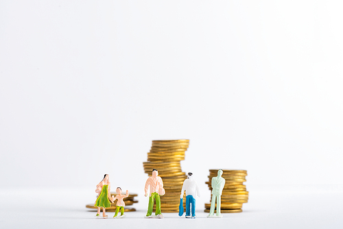 Concept of financial equality with people figures with stacked golden coins on white surface isolated on white