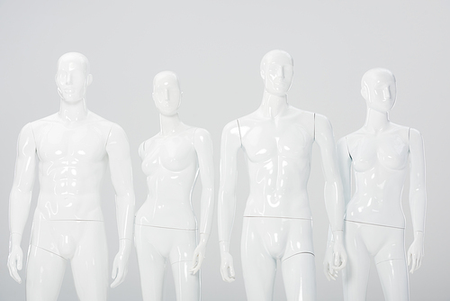 white plastic dummies in row isolated on grey