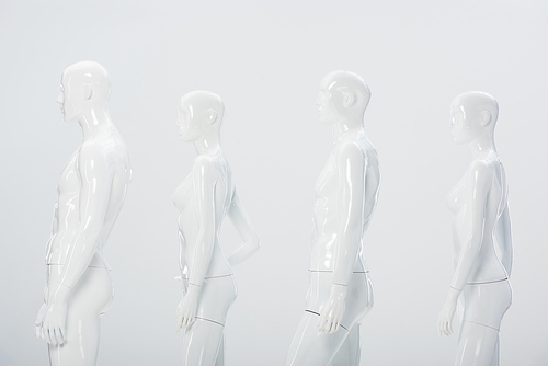 white plastic dummies in row isolated on grey