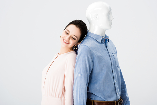 beautiful smiling girl posing with mannequin isolated on grey