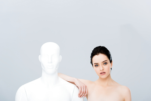 beautiful girl leaning on mannequin and  isolated on grey