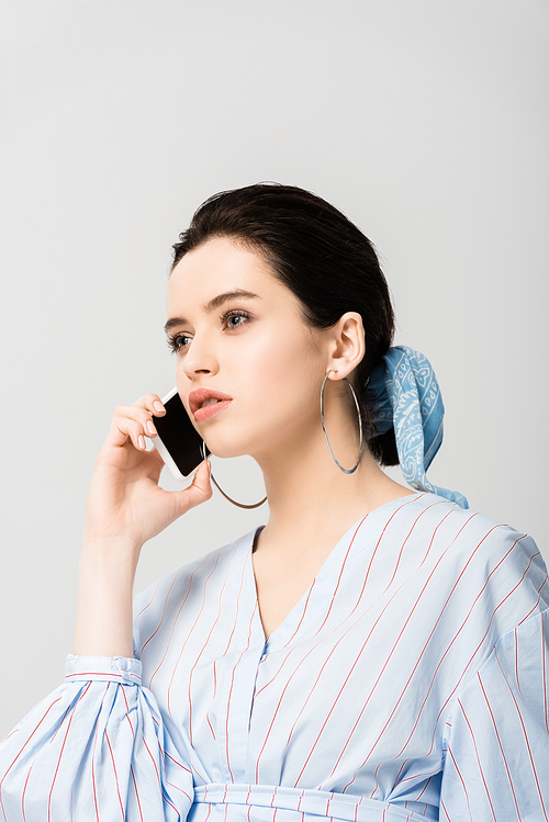 beautiful stylish girl talking on smartphone isolated on grey