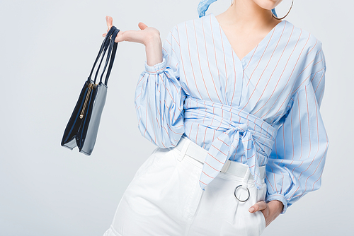 cropped view of stylish young woman with bag posing isolated on grey