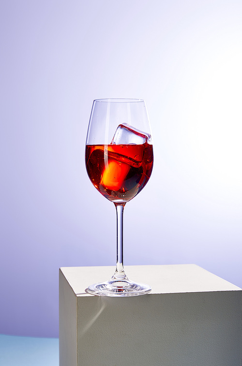 cocktail Aperol Spritz with ice cubes in glass on purple background