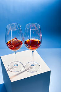 high angle view of cocktails Aperol Spritz with ice cubes in glasses on blue background