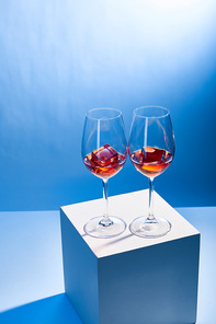 cocktails Aperol Spritz with ice cubes in glasses on blue background