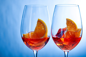 cocktails Aperol Spritz with ice cubes in glasses on blue background
