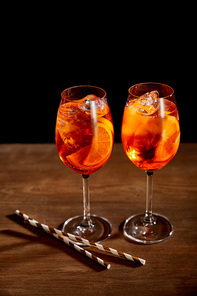 Aperol Spritz in glasses with straws on wooden table