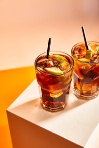 high angle view of cocktails cuba libre in glasses with straws on cube