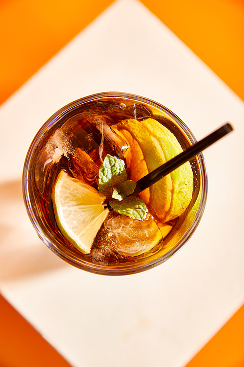 top view of cocktail cuba libre in glass with straw