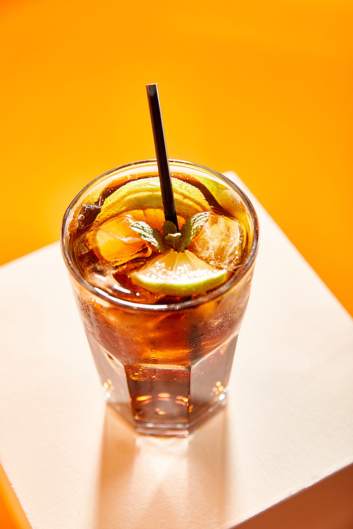 high angle view of cocktail cuba libre in glass with straw on cube