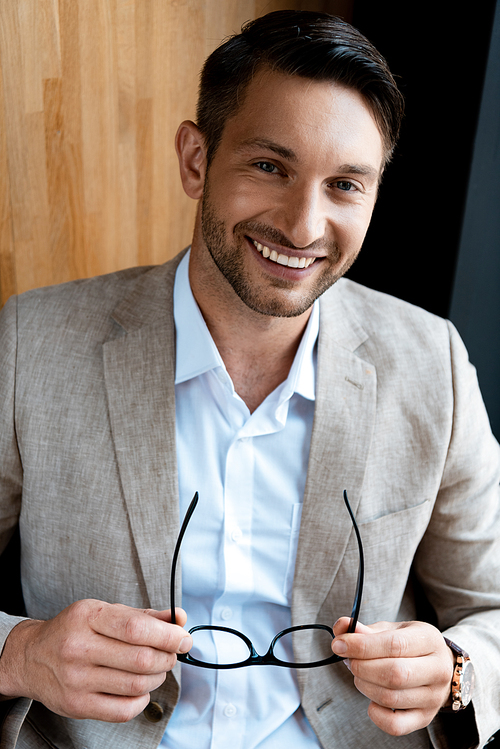 smiling businessman holding glasses and 