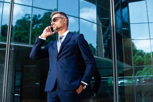 handsome man in suit and glasses talking on smartphone