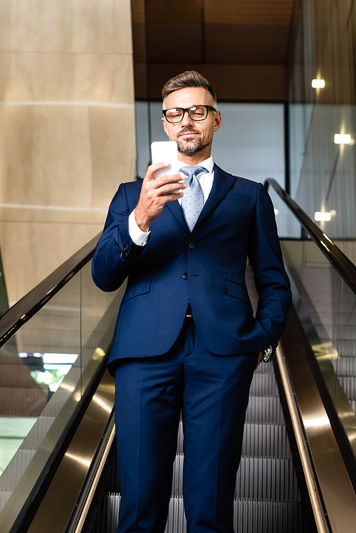 handsome businessman in suit and glasses talking on smartphone