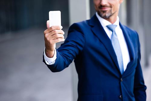 cropped view of businessman in formal wear talking selfie