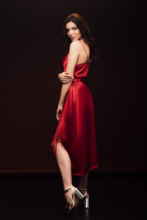 beautiful sensual woman in red dress posing and  isolated on black