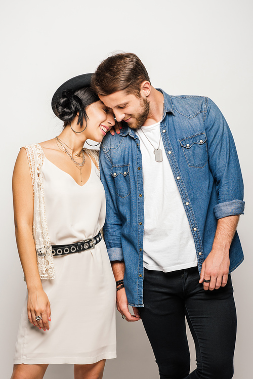 cute young couple holding hands and smiling on white background