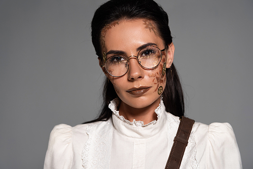front view of steampunk woman in glasses with makeup  isolated on grey