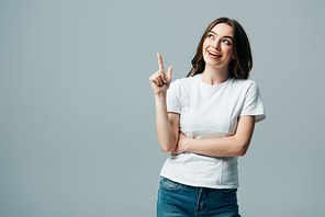 happy beautiful girl in white t-shirt showing idea gesture and looking away isolated on grey