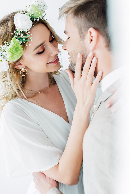 attractive bride and handsome bridegroom hugging and kissing with closed eyes