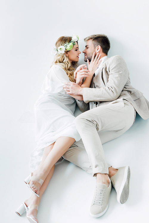 attractive bride and handsome bridegroom hugging and looking at each other