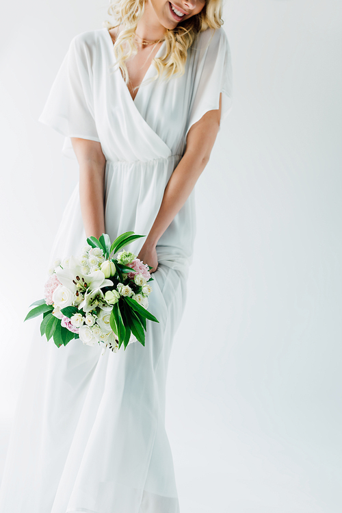 cropped view of bride in wedding dress holding bouquet isolated on white