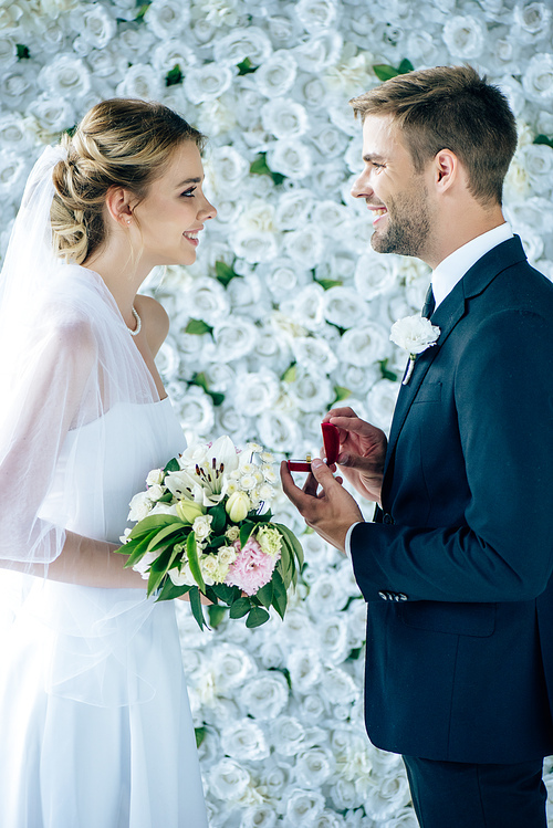 side view of bridegroom making proposal to bride in wedding dress