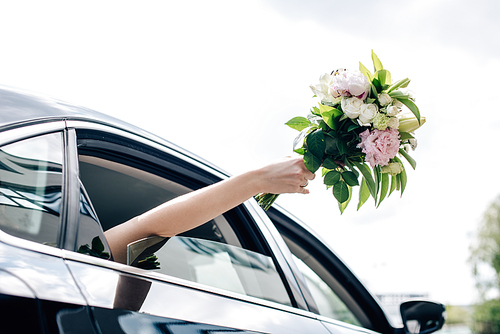 cropped view of young adult bride holding holding bouquet