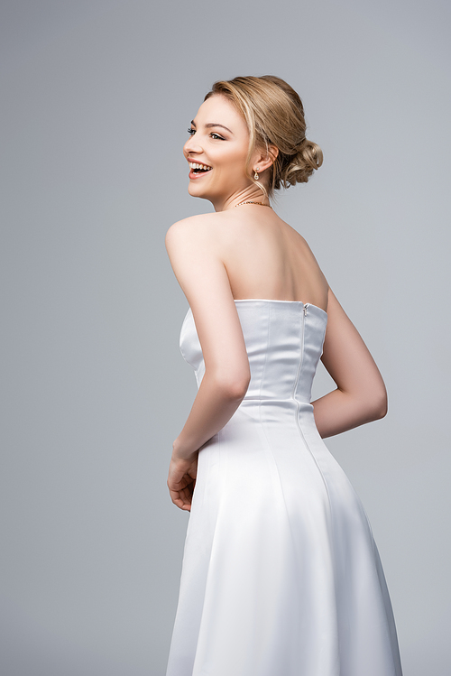 happy young bride in white wedding dress isolated on grey