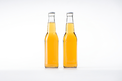 glass bottles of beer in row on white background