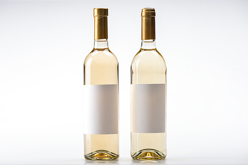 two bottles of white wine with blank labels on white background