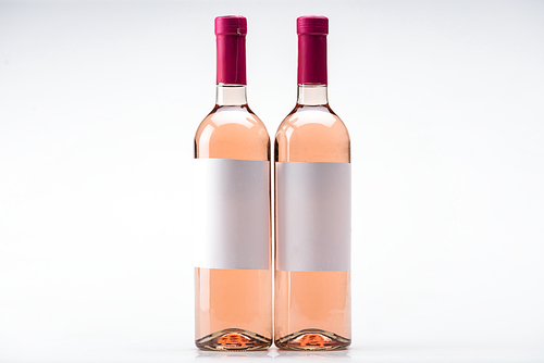 two bottles of rose wine with blank labels on white background