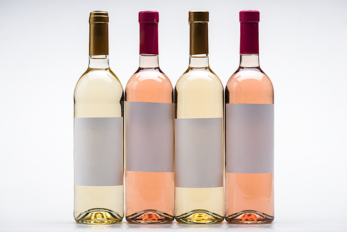 bottles of white and rose wine with blank labels on white background