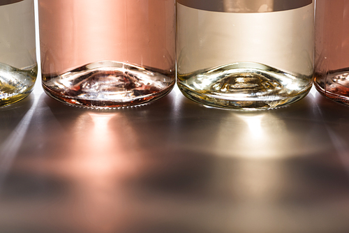 close up view of bottles of white and rose wine with light