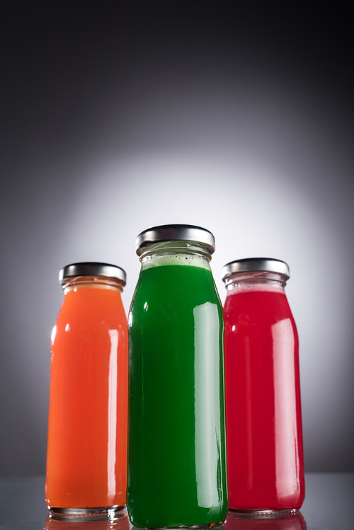 low angle view of bottles with colorful liquid on dark background with back light