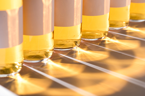 close up view of glass beer bottles with blank white labels and shadow