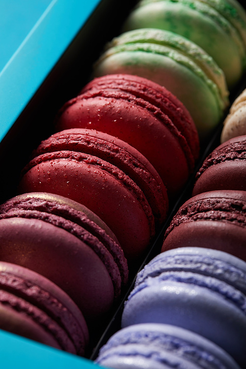 close up view of assorted delicious colorful french macaroons in box