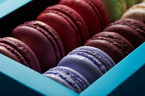 close up view of assorted delicious colorful french macaroons in box