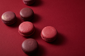 delicious colorful french macaroons on red background