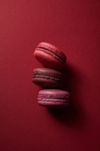 top view of delicious colorful french macaroons on red background