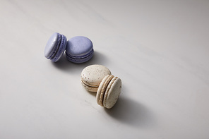 assorted delicious violet and white  french macaroons on grey background