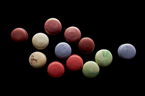 top view of assorted delicious colorful french macaroons isolated on black